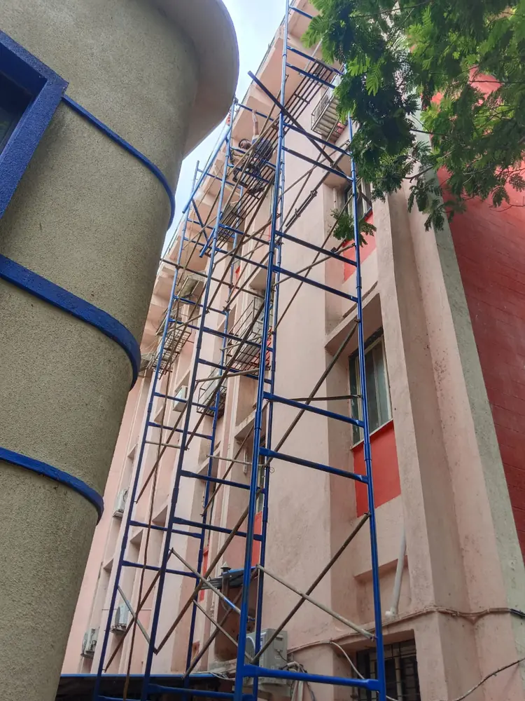 Narrow access scaffolding installed beside a building