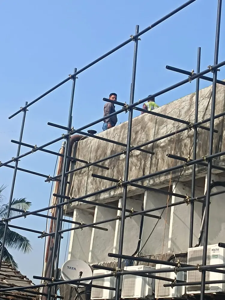 Workers assembling scaffolding at height